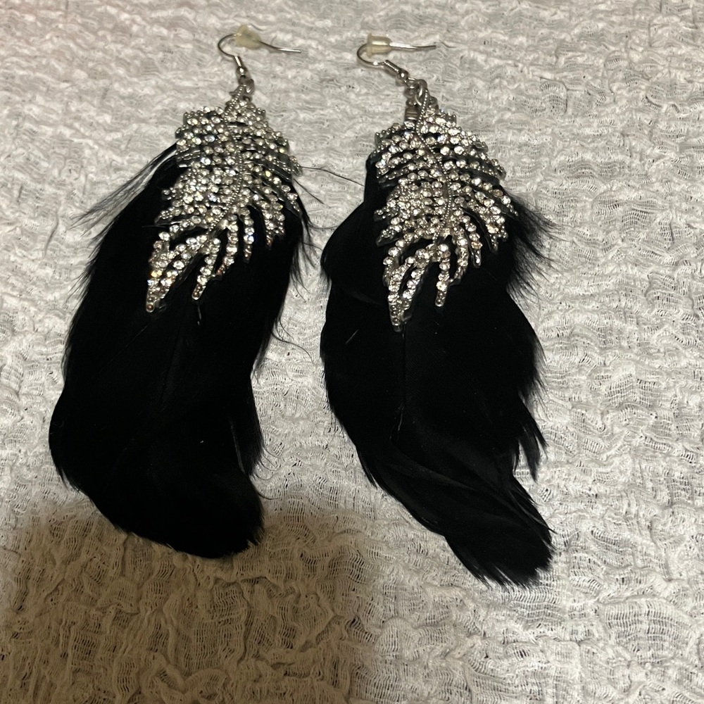 Earrings featuring long, dark, black ostrich feather with leaf rhinestones